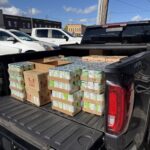 Cases of food being picke up by a truck