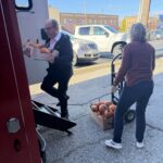 Volunteers helping load food pick up trucks